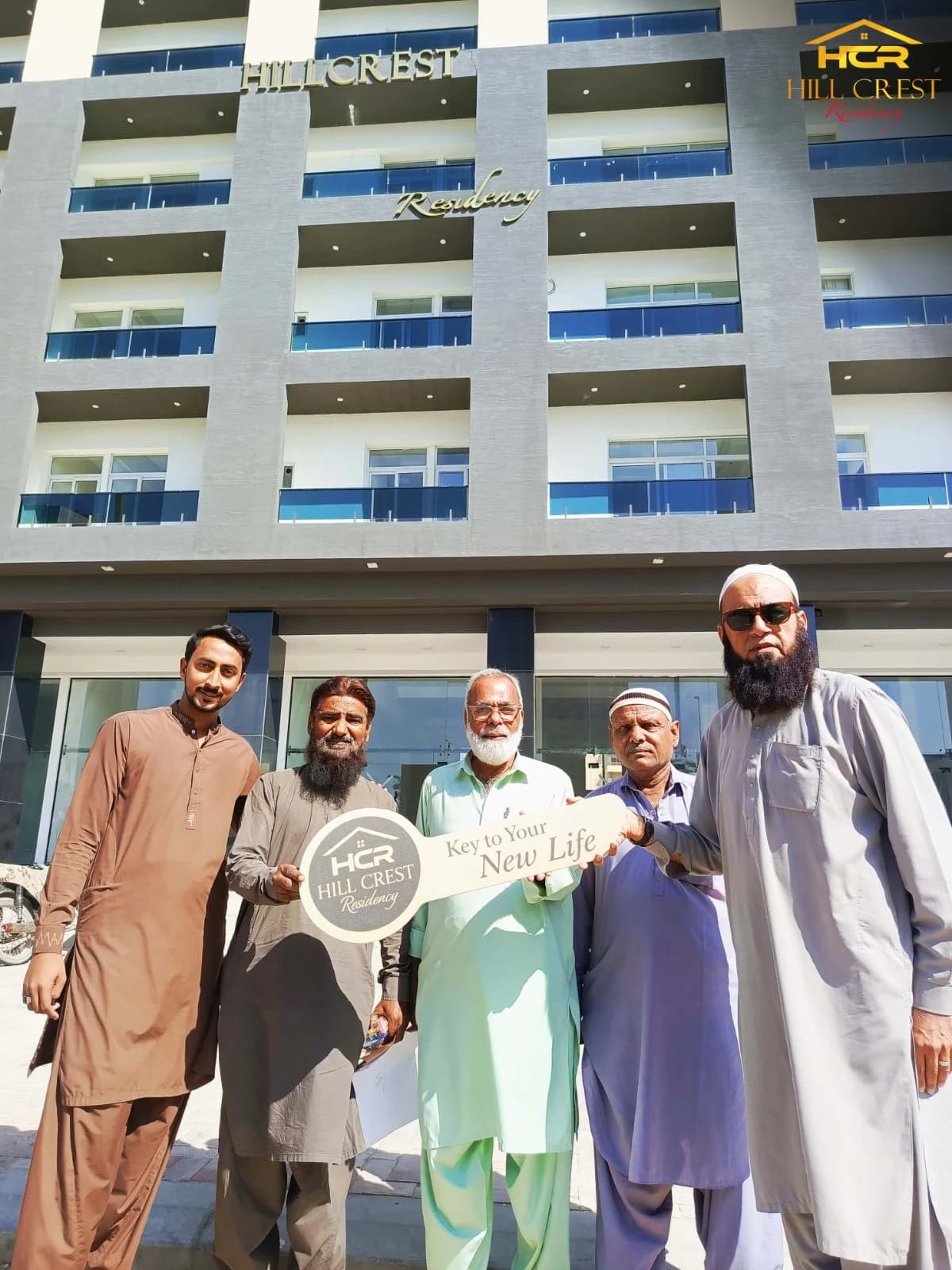 Hill Crest Residency team with happy owners holding possession certificates